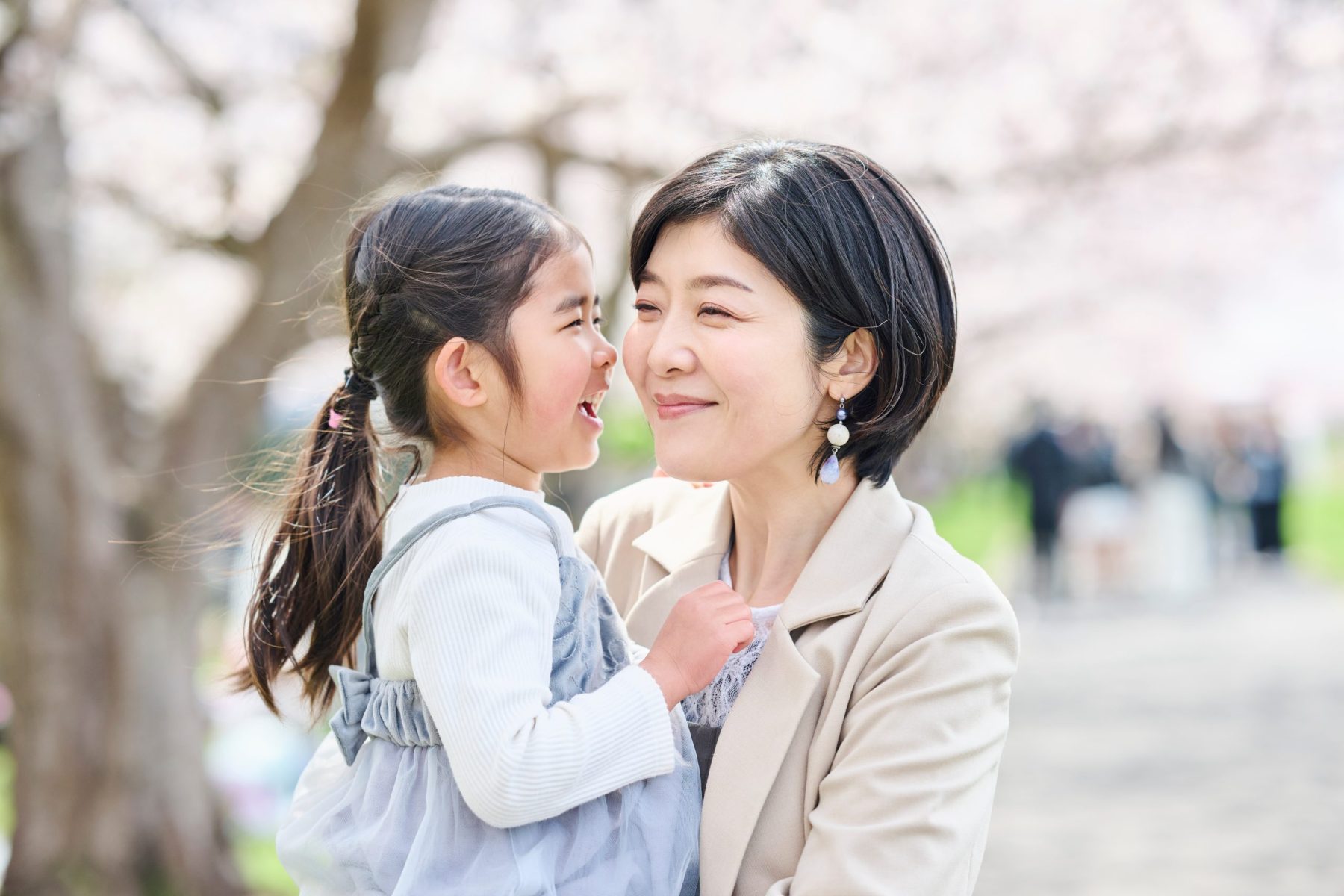 Woman holding little girl and smiling.