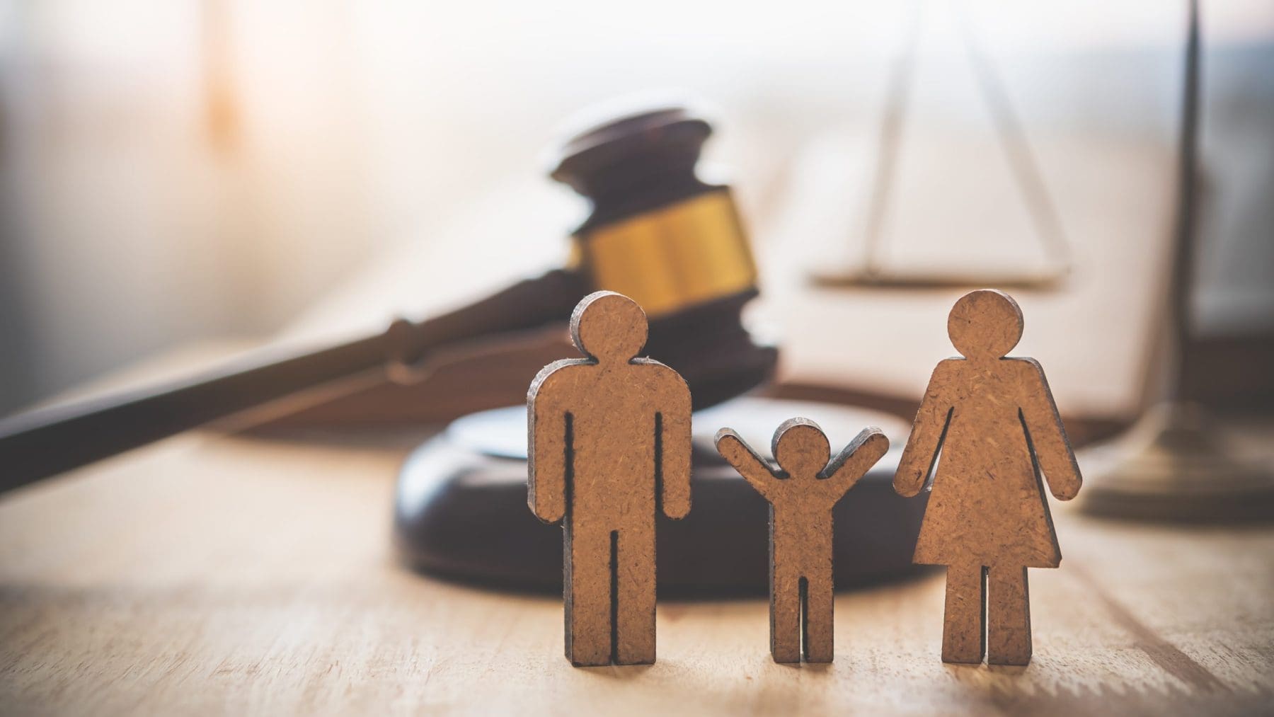 Family law concept with samll cardboard figures on table.