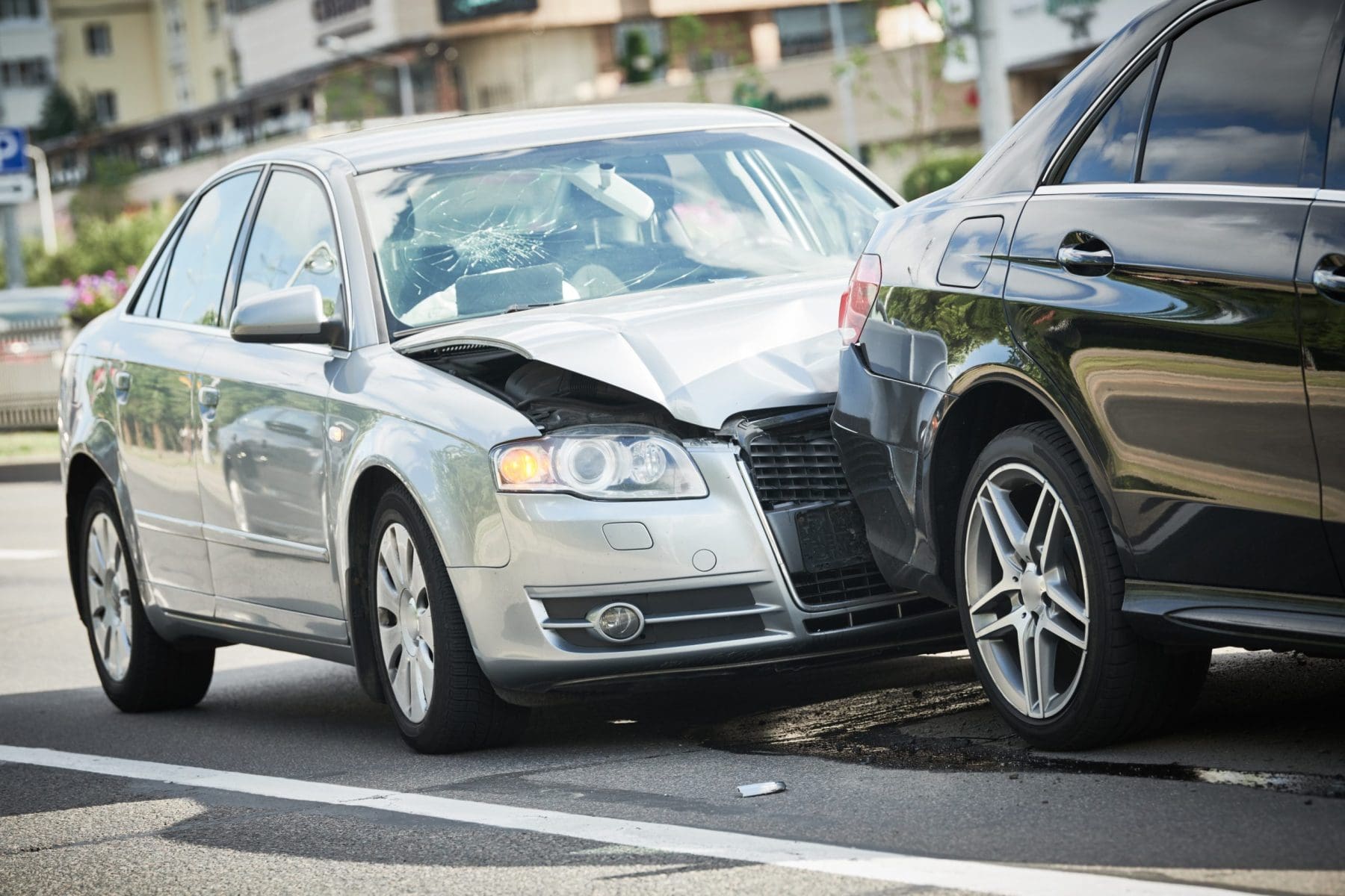 Car collision on city street. Two damaged automobiles.