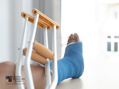 View of broken foot on cast laying on table with crotches and GSJ Law logo.
