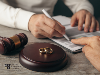 Person signing papers next to judge's gavel.