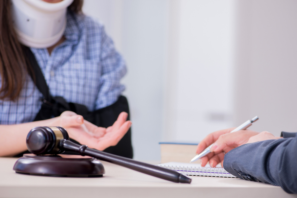 Woman with neck brace meeting with lawyer.